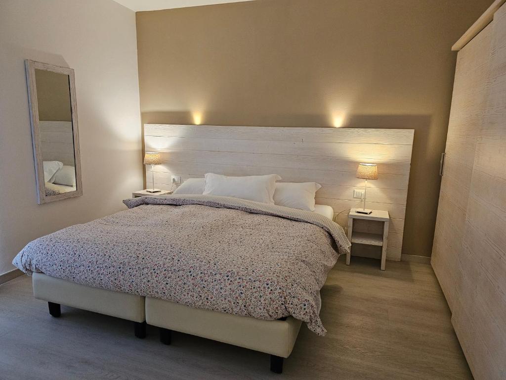 Mūsdienīga guļamistaba ar plašu gultu, viegliem toņiem un elegantu spoguli. Interjeru papildina mīksta gultas veļa un siltas gaismas avoti.