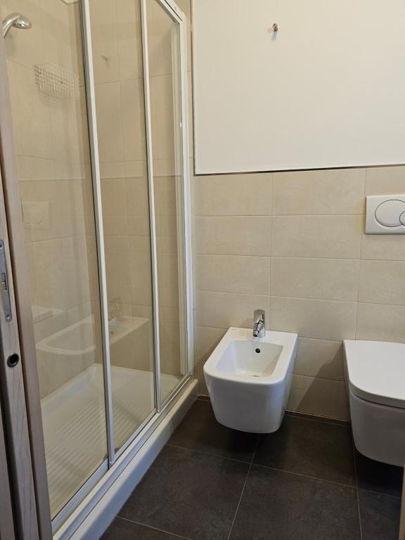 Mūsdienīgs vannas istabas interjers ar dušas kabīni, bidē un tualeti, veidots gaišās krāsās un flīzēs.