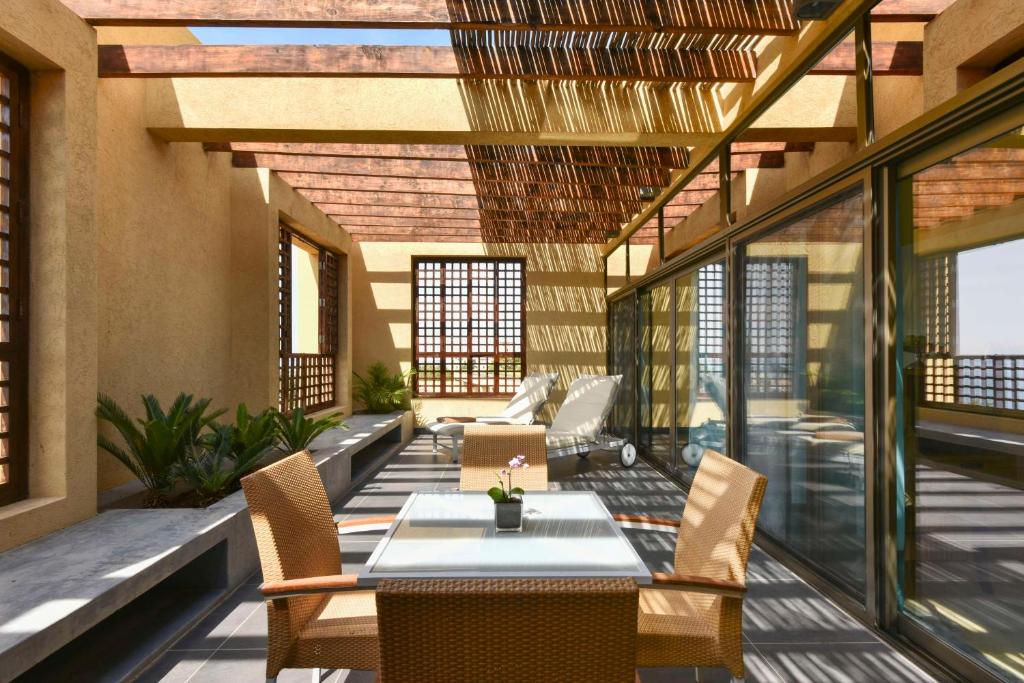 Mūsdienīgs terases dizains ar dabiskiem materiāliem un ērtu mēbelējumu, kas nodrošina relaksējošu atmosfēru. Gaismas un ēnas spēle rada patīkamu noskaņu.