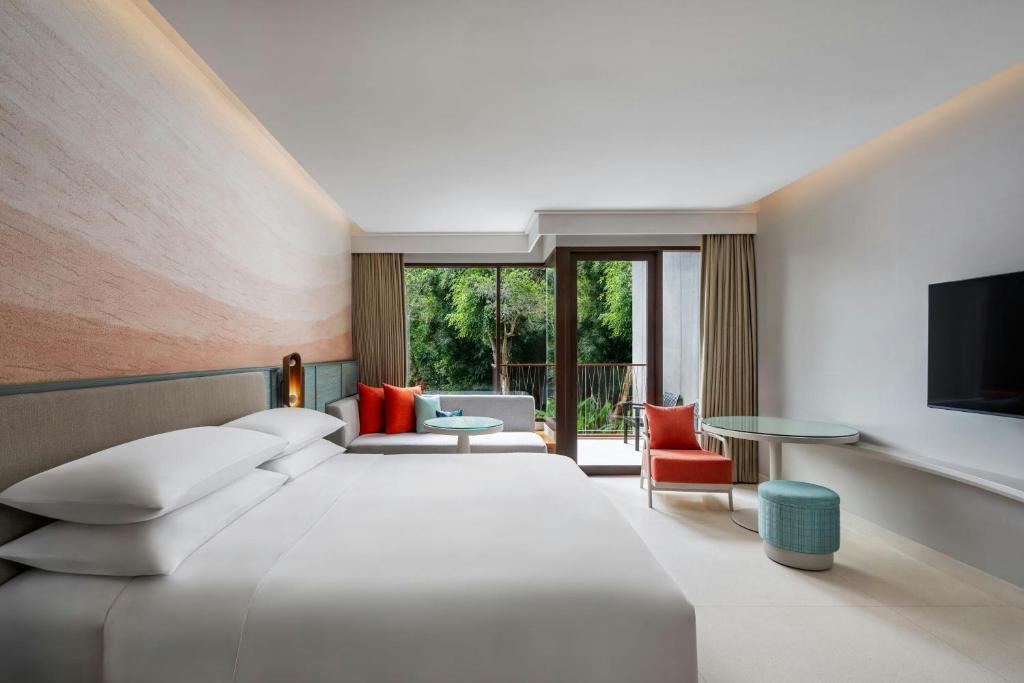 Mūsdienīgs viesnīcas numurs ar ērtu gultu, stilīgu mēbelējumu un skatu uz zaļo dārzu. Telpa ir gaiša un gaumīgi iekārtota, nodrošinot relaksējošu atmosfēru.