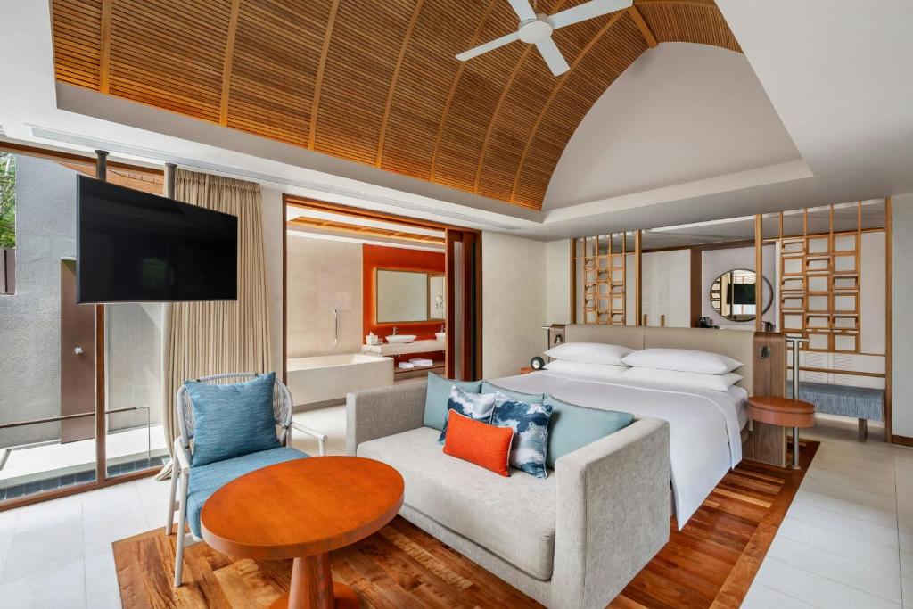 Mūsdienīgs viesnīcas numurs ar elegantu interjeru, koka griestiem un atvērto plānojumu, kas ietver viesistabu un guļamistabu. Numurā ir televizors, dīvāns un galdiņš, radot mājīgu atmosfēru.