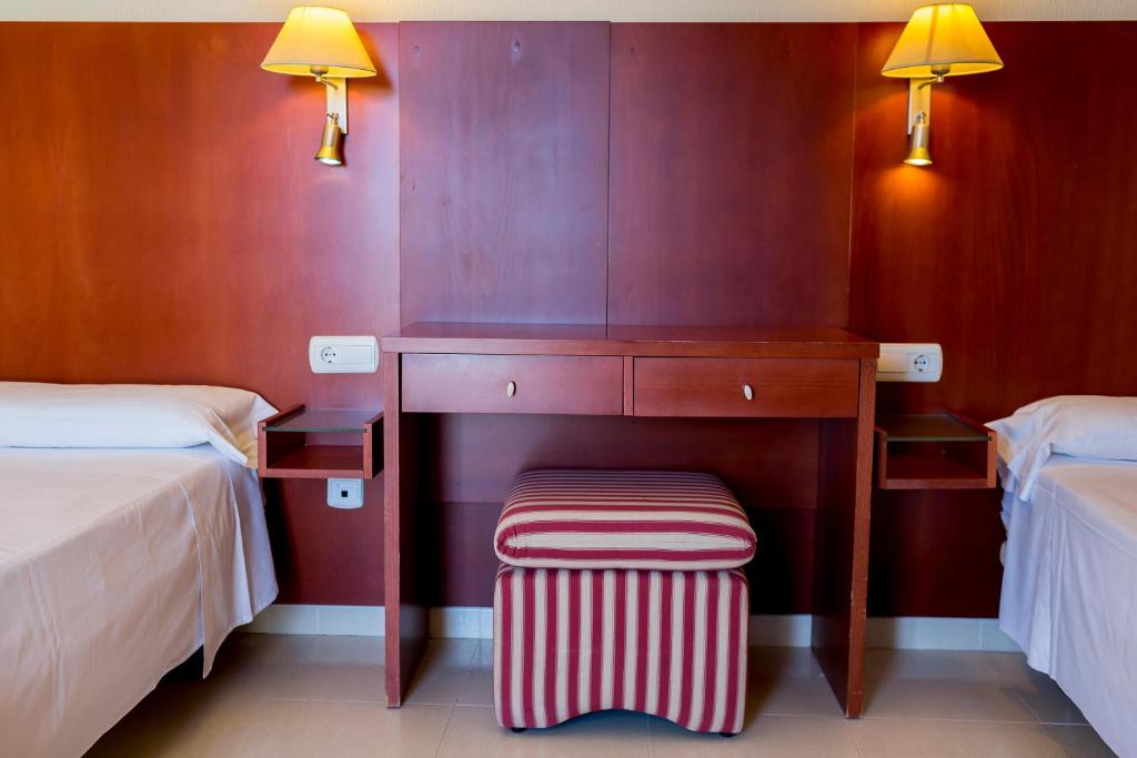 Gulēšanas telpa ar divām gultām, koka galdu un krēslu, kā arī siltām lampām uz sienām. Interjers ir vienkāršs un moderns, radot patīkamu atmosfēru.