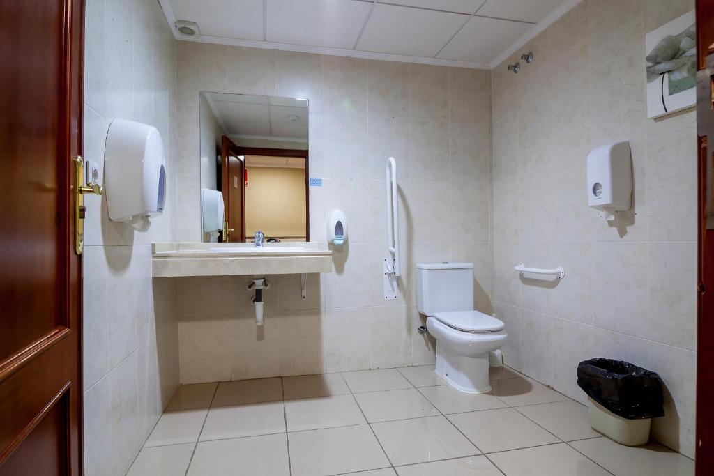 Tīra un moderni iekārtota tualete ar izlietni, spoguli un papīra salvetēm. Telpā ir pieejami arī atbalsta rokturi un atkritumu kaste.