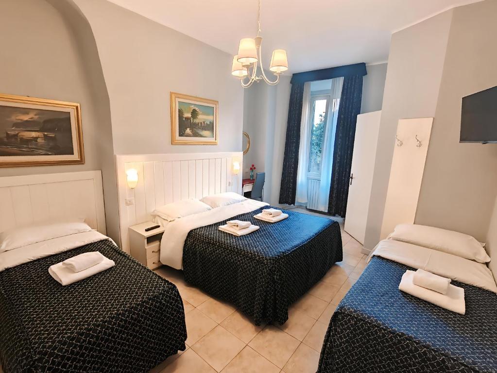 Mūsdienīga viesnīcas numura iekārtojums ar trim gultām, gaismas ķermeņiem, gleznām uz sienām un logiem, kas nodrošina dabisko apgaismojumu. Numurs ir komfortabls un viesmīlīgs, ideāli piemērots ģimenēm vai grupām.