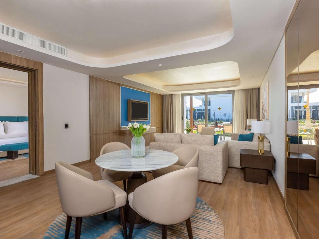 Mūsdienīgs viesnīcas numurs ar brīnišķīgu interjeru, kas ietver ērtu atpūtas zonu, ēdamgaldus un plašus logus, caur kuriem ieplūst dabiska gaisma. Tas ir ideāli piemērots komfortablai atpūtai.