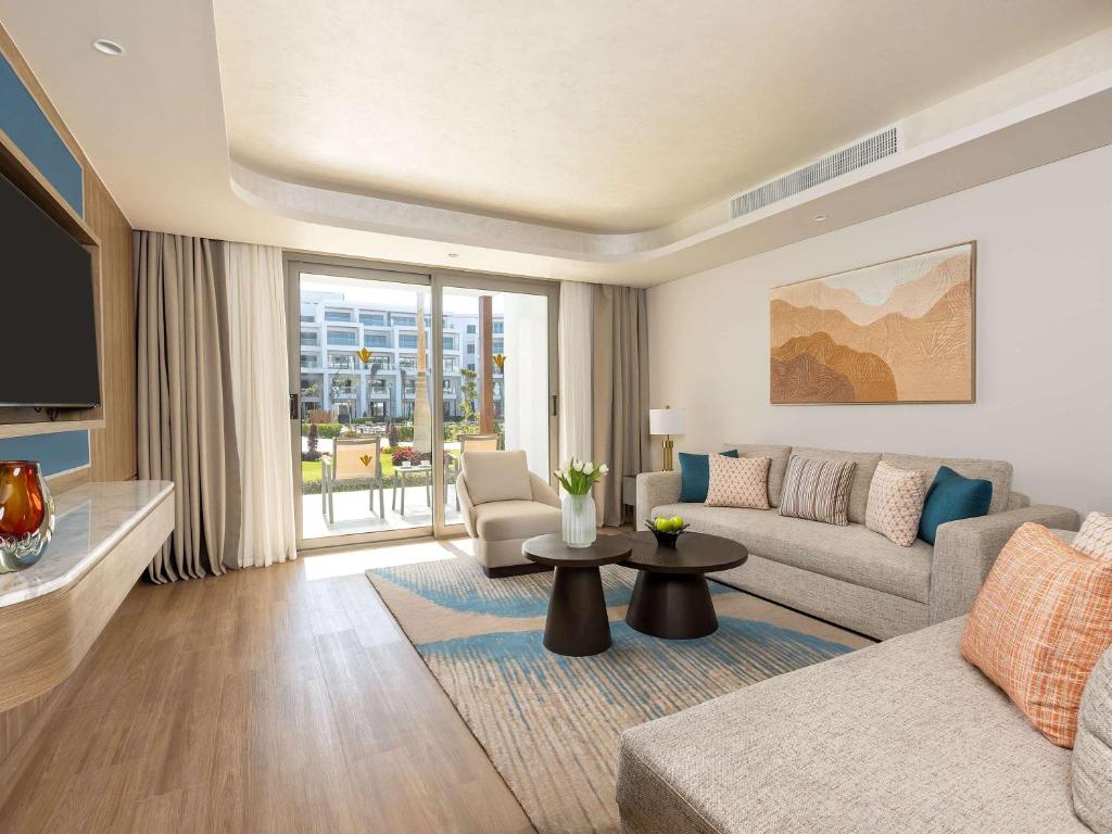 Mūsdienīgs viesnīcas numurs ar plašu dzīvojamo zonu, komfortablām mēbelēm un skatu uz dārzu. Interjers apvieno neitrālas krāsas ar siltām akcentu toni.