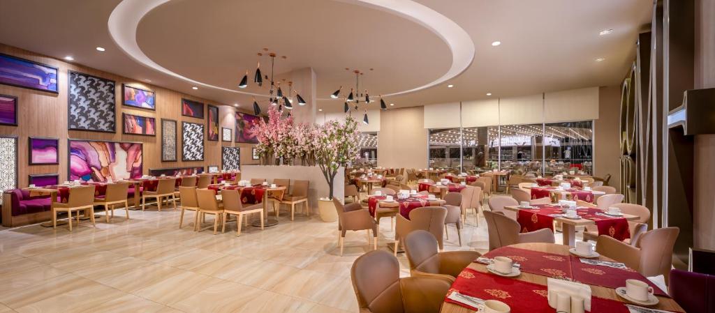 Moderns restorāns ar siltu apgaismojumu un mākslinieciskām sienām, kurā ir eleganti galdi un krēsli, rotāti ar ziediem un mākslas darbiem. Ideāli piemērots ēdienreižu baudīšanai.