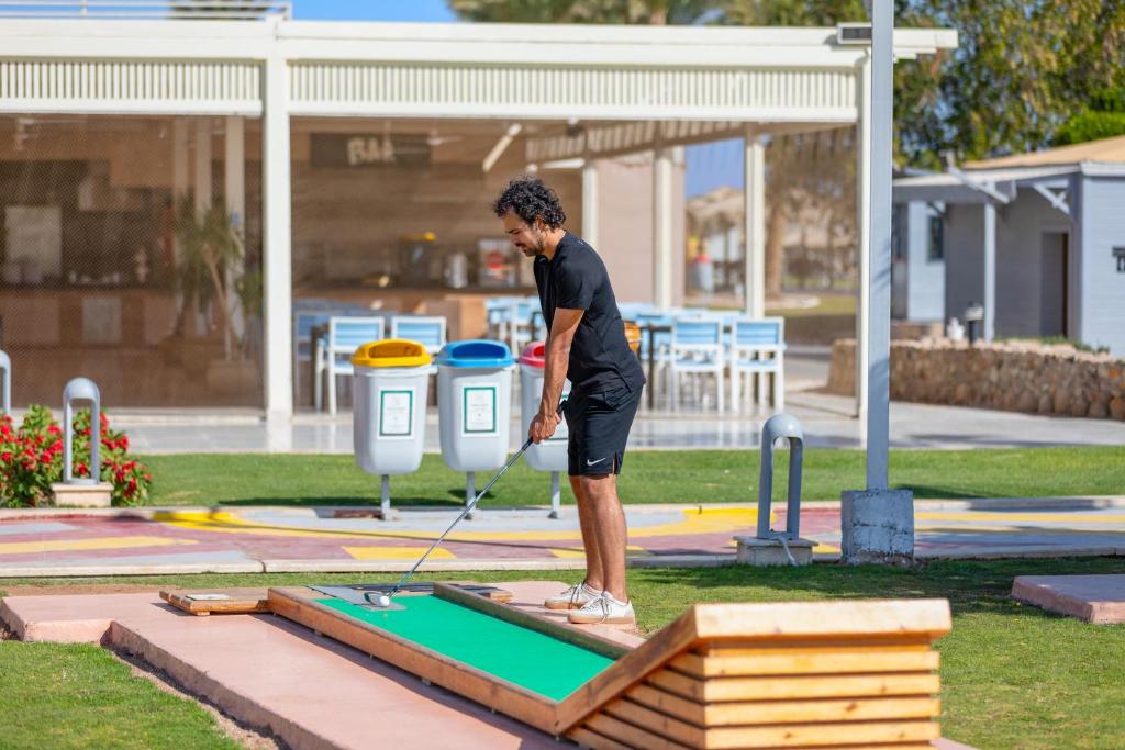 Vīrietis spēlē mini golfu pie Pickalbatros Royal Albatros Moderna.