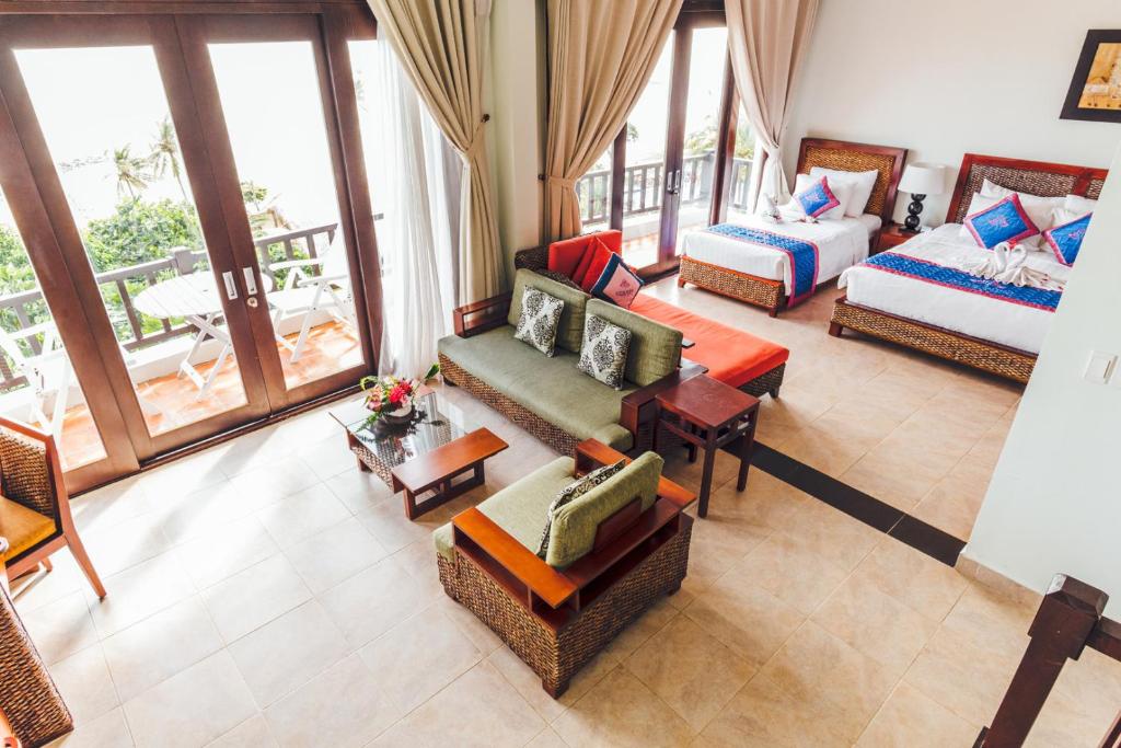 Gaisa skats uz viesnīcas numuru ar divām gultām, viesistabu un balkonu. Telpā ir moderni mēbeļu komplekti un dabīgas gaismas plūsma.