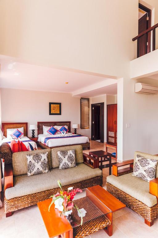 Mūsdienīgs viesnīcas numurs ar viesistabu un guļamistabu, kurā ir ērti mēbelēti dīvāni un gultas. Telpa ir gaiša un gaumīgi iekārtota, ar dekoratīvām spilveniem un augu kompozīcijām.