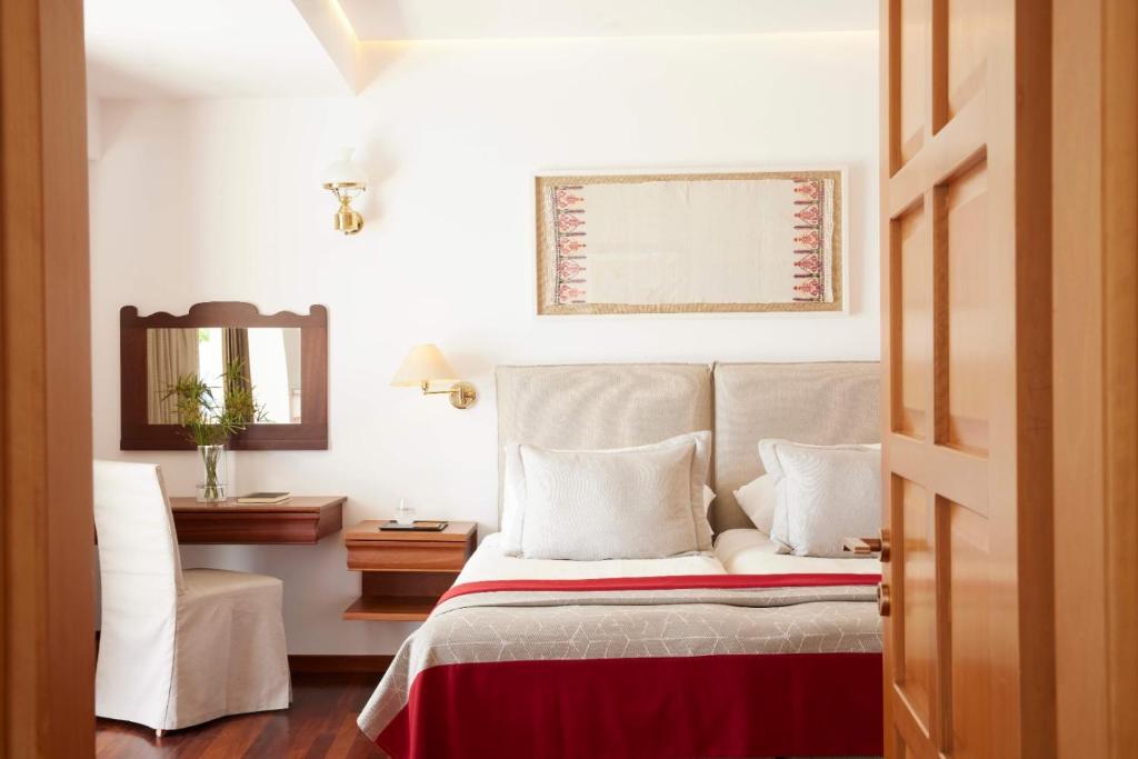 Mūsdienīgs guļamistabas interjers ar gultu, rakstāmgaldu un spoguli, rotāts ar māksliniecisku sienas gleznām. Siltas krāsas un koka elementi rada viesmīlīgu atmosfēru.