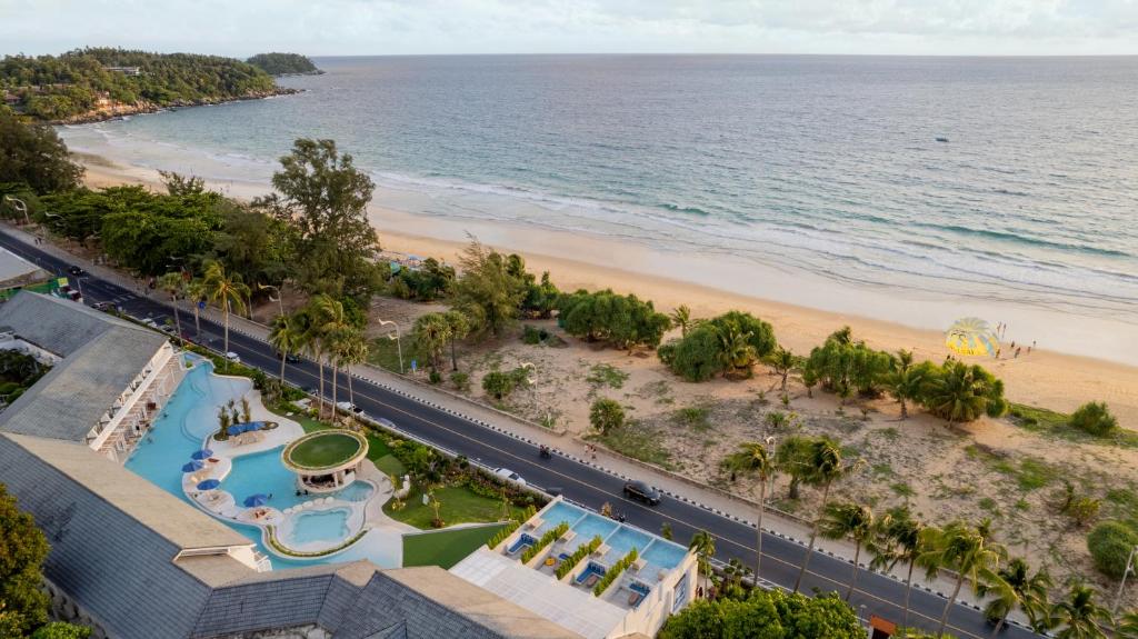 Pludmales un viesnīcas ainava ar baseinu un palmu kokiem, blakus mierīgai jūrai. Ideāla vieta atpūtai un izklaidei.