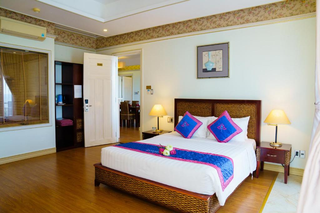 Mūsdienīgs guļamistabas interjers ar divguļamo gultu, dekora spilveniem un lampām, kas nodrošina siltu apgaismojumu. Telpā ir arī skapis un piekļuve viesistabai.