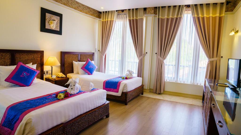 Mūsdienīgs viesnīcas numurs ar divām gultām, dekora elementi un dabīgais apgaismojums. Numurā ir koka grīda, televizors un lieli logi ar aizkariem.