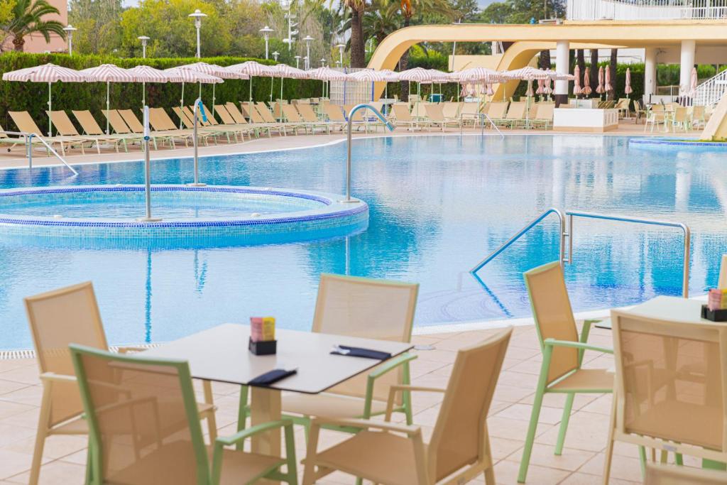 Āra baseins ar sauļošanās krēsliem un lietussargiem, kas izvietoti gar baseina malu, radot relaksējošu atmosfēru. Blakus baseinam ir galdi un krēsli, ideāli piemēroti atpūtai un baudīšanai.