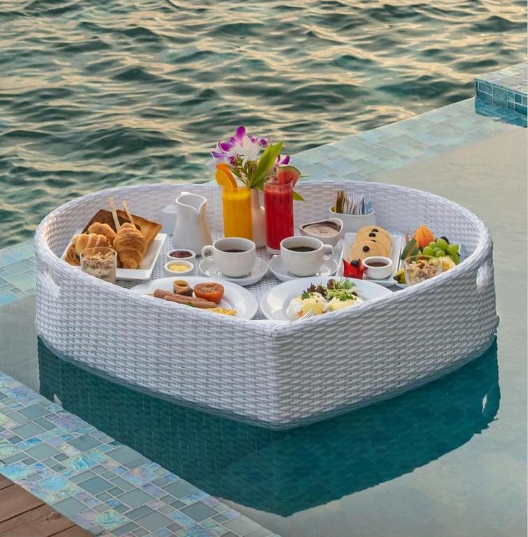 Romantisks brokastu pasniegšanas grozs uz ūdens, saturot kafiju, sulas, konditorejas izstrādājumus un svaigus augļus. Ideāls veids, kā baudīt maltīti brīvā dabā.