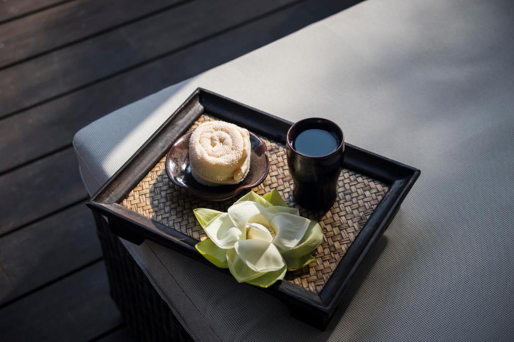 Traukā ir salvetes rullis, kafijas krūze un ziedi, kas izkārtoti uz vītnes.