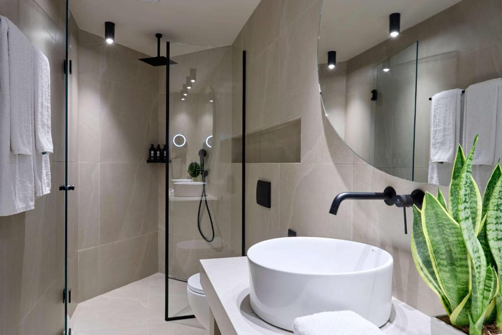 Mūsdienīgs vannas istabas interjers ar dušu un elegantu izskatu Mirabello Bay Luxury Resort.
