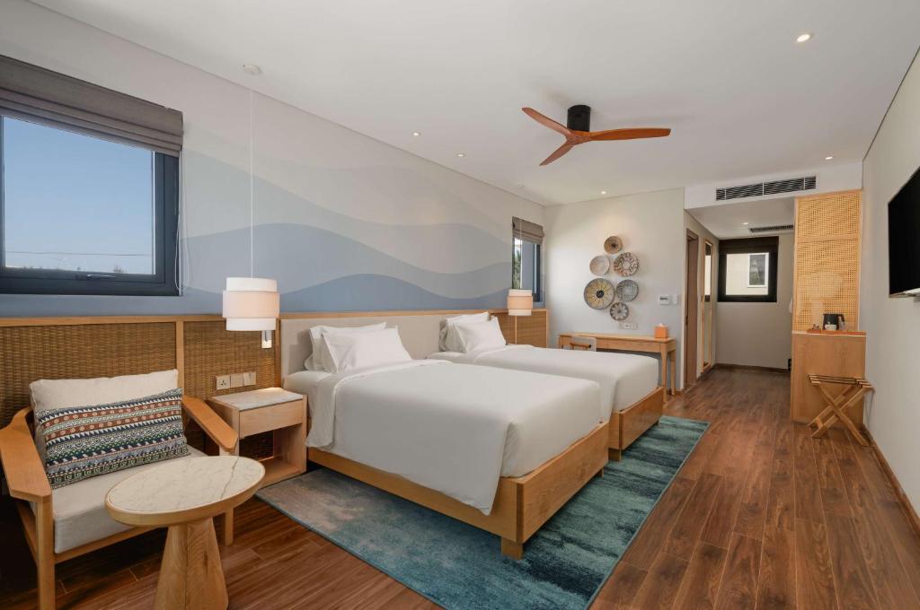 Radisson Resort Mui Ne modern numurs ar divām gultām un pludmales stilu.