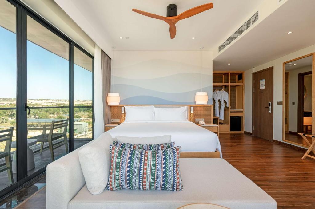 Radisson Resort Mui Ne numurs ar balkonu un skatu uz dabu.