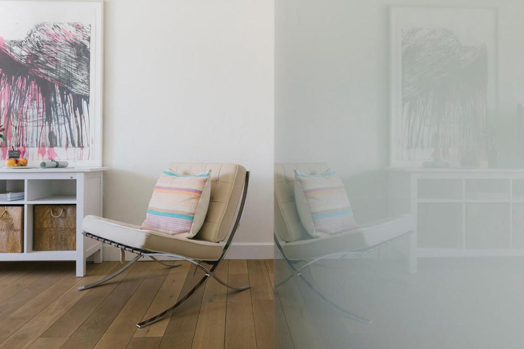 Mūsdienīgs interjers ar elegantām mēbelēm, tostarp komfortablu krēslu un stilīgu mākslas darbu uz sienas. Gaismas un telpas harmonija rada relaksējošu atmosfēru.