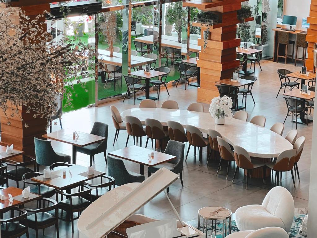 Moderns restorāns ar elegantiem galdiem un krēsliem, ziedu dekori un atvērtu telpu. Gaisīgas iekārtojuma detaļas rada patīkamu atmosfēru.