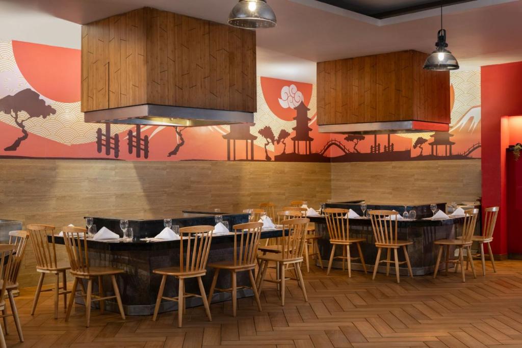 Mūsdienīgs restorāns ar stilīgu interjeru un siltu apgaismojumu, dekorēts ar Āzijas tematiku, ieskaitot zīmējumus uz sienām. Sēdvietas pie galdiem ar eleganti salocītām galdautām.