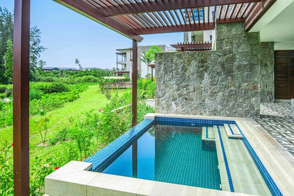 Mūsdienīgs mājas pagalms ar privātu baseinu, akmens sienu un zaļo dārzu apkārt. Ideāla vieta relaksācijai un atpūtai.