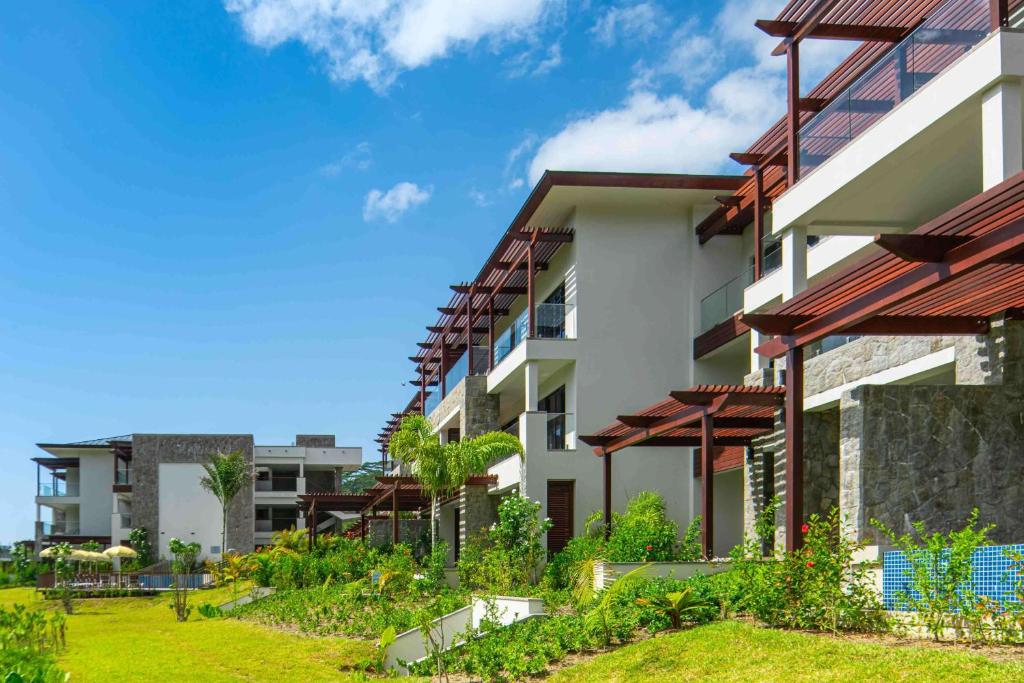 Mūsdienīgas viesnīcas ar zaļām ainavām un skaidrām debesīm, radot relaksējošu atmosfēru.