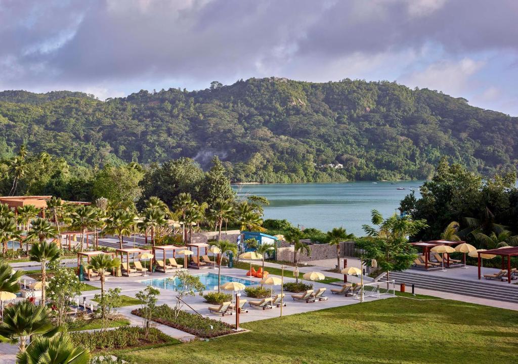 Skaista kūrorta ainava ar baseinu, palmām un kalniem fona, kas rada relaksējošu atmosfēru. Ideāla vieta atpūtai un atjaunošanai.