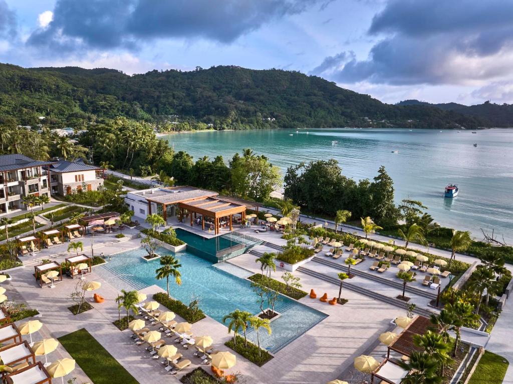 Luksusa kūrorta skats ar baseinu un pludmali, apkārt palmām un kalniem. Ideāla vieta atpūtai un relaksācijai.