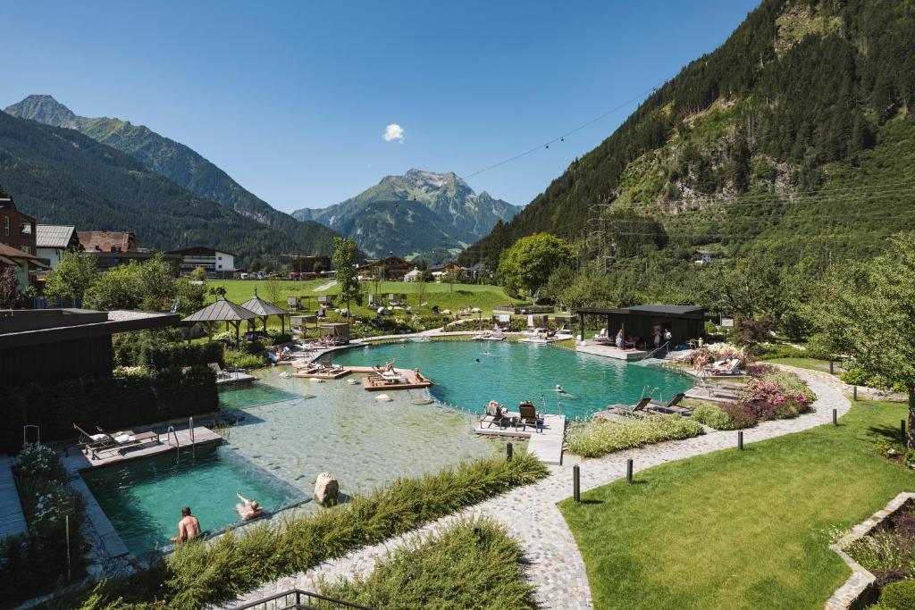 Lieliska ainava ar peldbaseiniem un kalniem fonā, kas rada relaksējošu atmosfēru. Viesi baudīja atpūtu pie ūdens, apzaļumotā vidē.