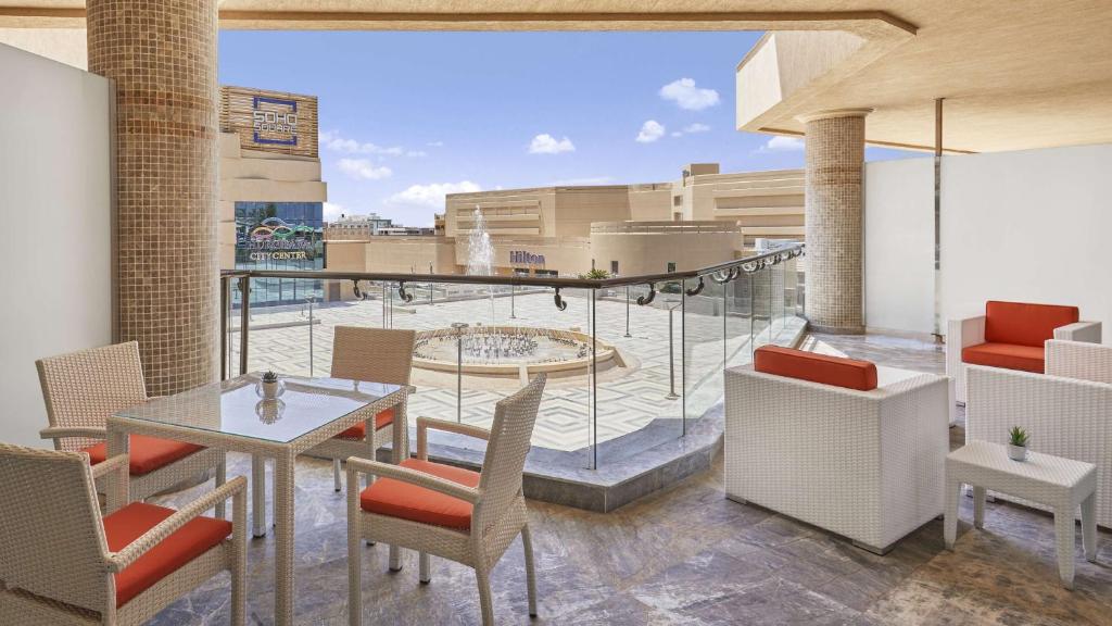 Terasē ir eleganti mēbelētas zonas ar galdiem un krēsliem, no kurām paveras skats uz pilsētas laukumu un Hilton viesnīcu. Gaisma un moderna arhitektūra rada relaksējošu atmosfēru.