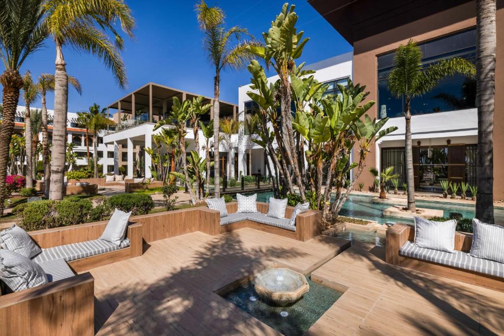 Moderns dārzs ar palmām un zaļumiem, kurā ir komfortabli sēdvietas un ūdens elements, nodrošina relaksējošu atmosfēru. Gaismas un dabas harmonija rada ideālu vietu atpūtai.