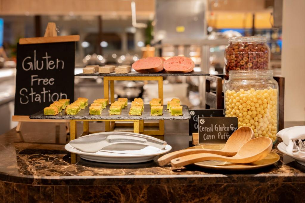 Bezcukura stacija ar dažādiem bezglutēna ēdieniem, tostarp saldumiem un graudaugiem, atrodas viesnīcas bufetē. Galda rotāšana ar melnu tāfeli, uz kuras rakstīts 