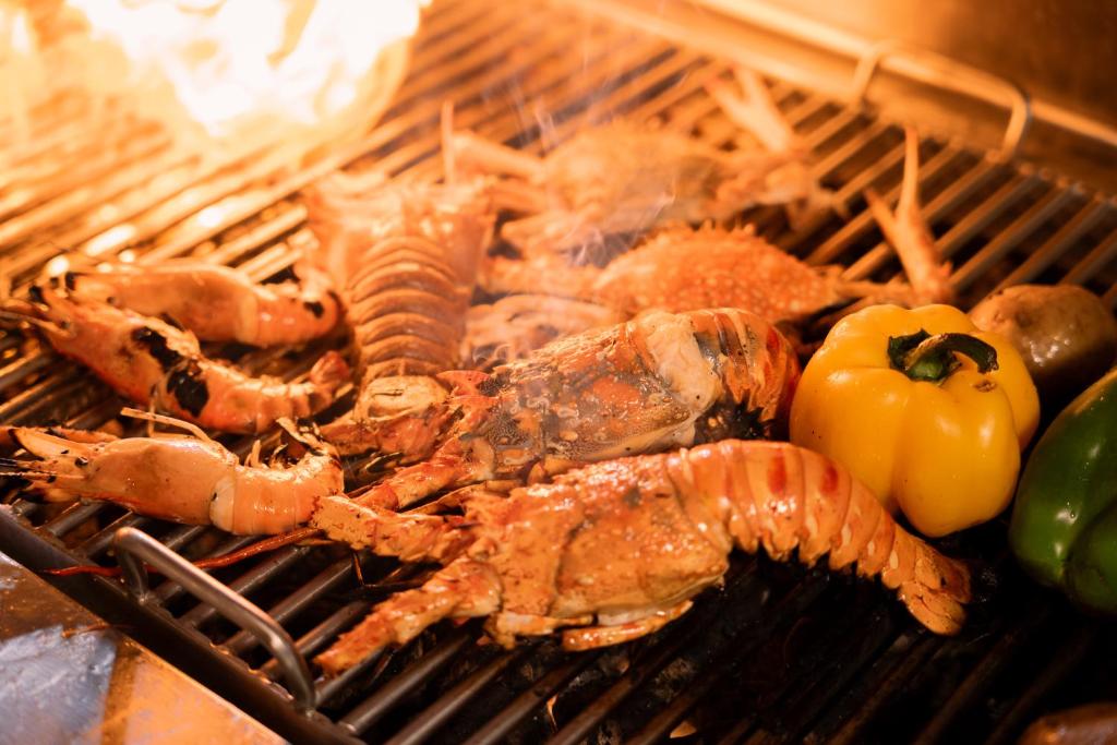 Grilētie jūras produkti ar dārzeņiem, tostarp garnelēm, krabjiem un pipariem, rada garšīgu un krāsainu skatu.