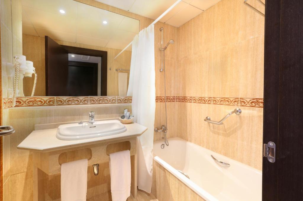 Moderns vannas istabas interjers ar vannu, izlietni un higiēnas piederumiem. Siltas krāsas un elegants dizains rada patīkamu atmosfēru.