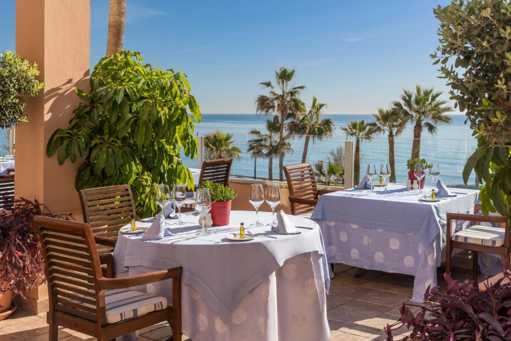 Skaists restorāns ar terasi, kas piedāvā brīnišķīgus skatus uz jūru un palmām, ideāli piemērots romantiskām vakariņām vai relaksējošiem brīžiem.