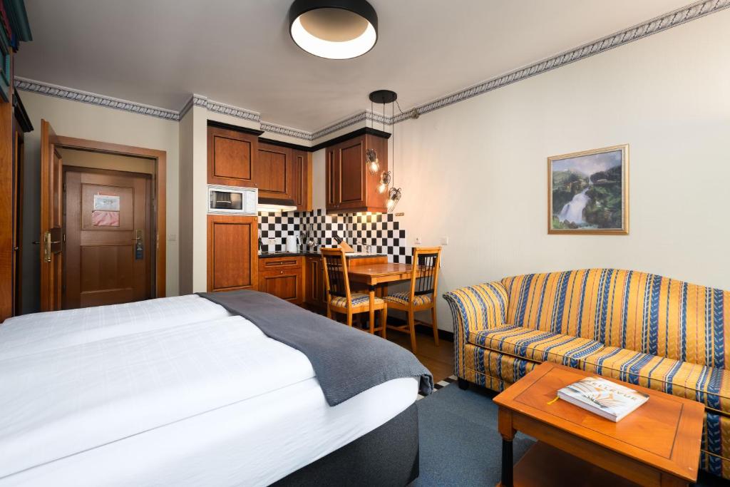 Mūsdienīgs viesnīcas numurs ar koka mēbelēm, mini virtuvi un ēdamgaldu. Numurā ir ērts dīvāns un moderns apgaismojums.