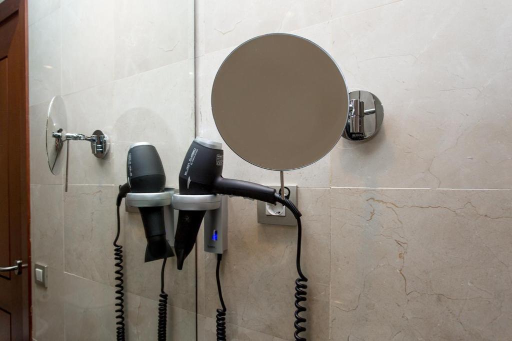 Fēnu un spoguli vannasistabā pie sienas, izmantojot modernu dizainu un praktiskus aksesuārus. Ideāls risinājums matu žāvēšanai un veidošanai.