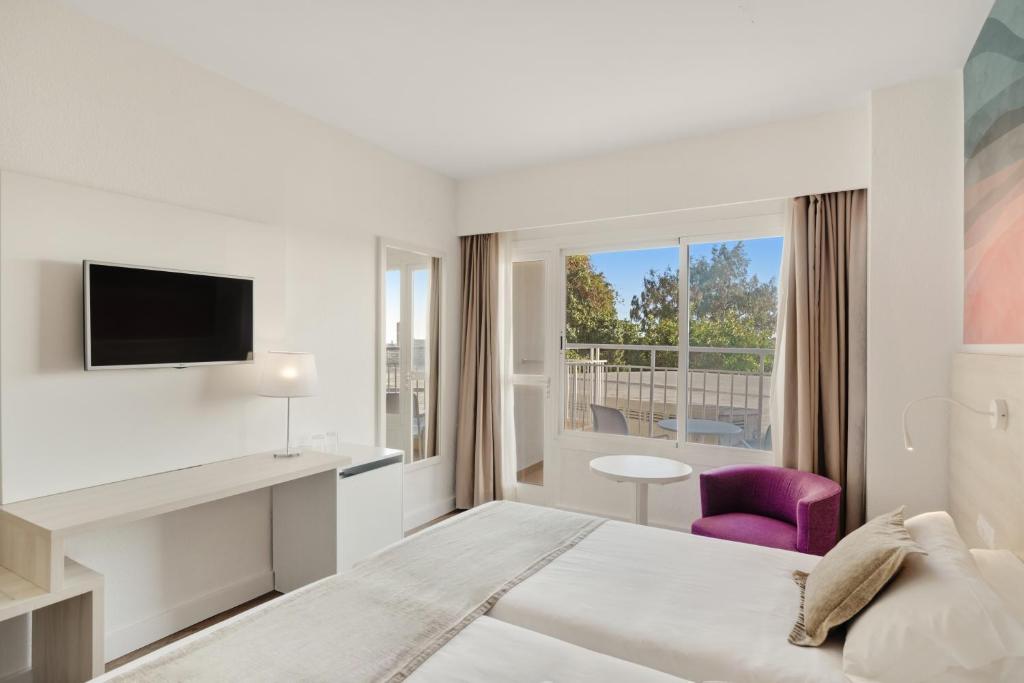 Mūsdienīgs viesnīcas numurs ar divām gultām, televizoru un balkonu, kas piedāvā skatu uz ārpusi. Interjers ir gaišs un elegants, ar modernu mēbelējumu un komfortablu sēdvietu.