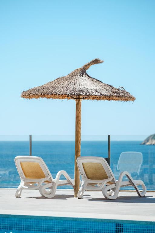 Peldbaseins ar saules krēsliem un salmu jumtu, kas atrodas pie jūras, radot relaksējošu atmosfēru. Ideāla vieta atpūtai un saulē baudīšanai.