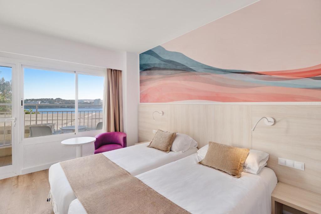 Mūsdienīgs viesnīcas numurs ar divām gultām un elegantu sienas gleznojumu, kas atspoguļo maigas krāsas. Logā redzams skats uz pludmali un jūru.