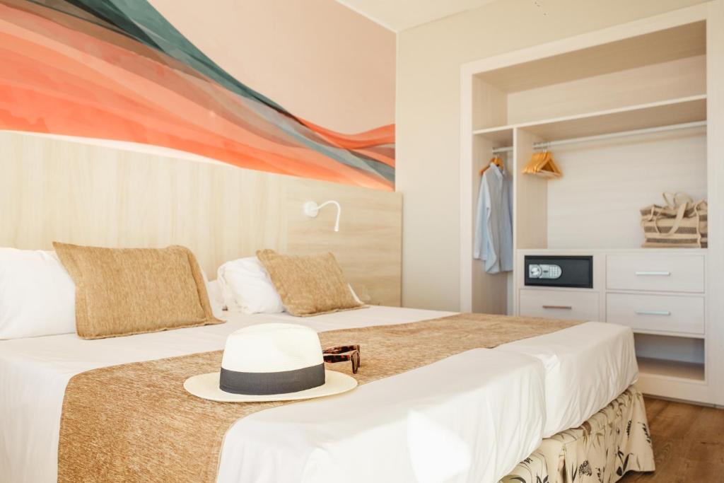 Mūsdienīgs viesnīcas numurs ar divām gultām, dabīgām krāsām un dekoratīviem spilveniem, kā arī skapjiem un drošības seifu. Interjerā ir siltas krāsas un mākslinieciska siena ar viļņainu rakstu.