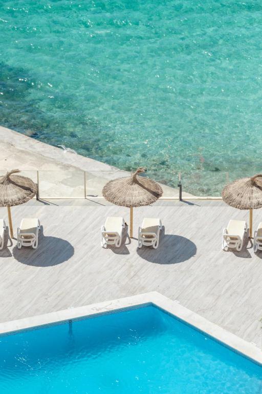 Peldbaseins ar saulessargiem un pludmales krēsliem pie skaidra ūdens. Ideāla vieta atpūtai un relaksācijai.