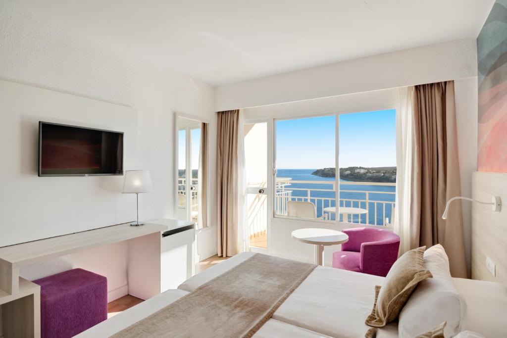 Mūsdienīgs viesnīcas numurs ar skatu uz jūru, ietver televizoru, gaišu interjeru un ērtu mēbelējumu. Ideāla vieta atpūtai un relaksācijai.