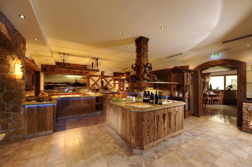 Kāzās iekārtota kafejnīca ar koka un akmens elementiem, kas rada siltu un viesmīlīgu atmosfēru. Interjerā ir redzami eleganti mēbeļu risinājumi un apgaismojums.