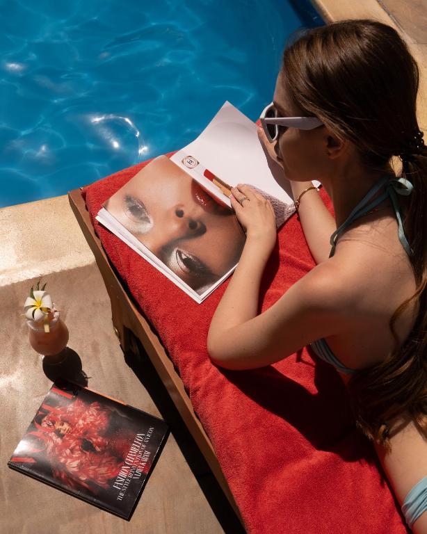 Sieviete lasot žurnālu pie baseina Media Rotana.