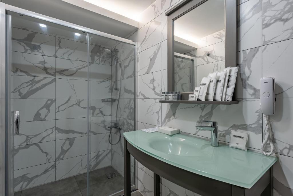 Mūsdienīga vannas istaba ar stikla dušu viesnīcā Bergiz Hotels & Resort Kemer.
