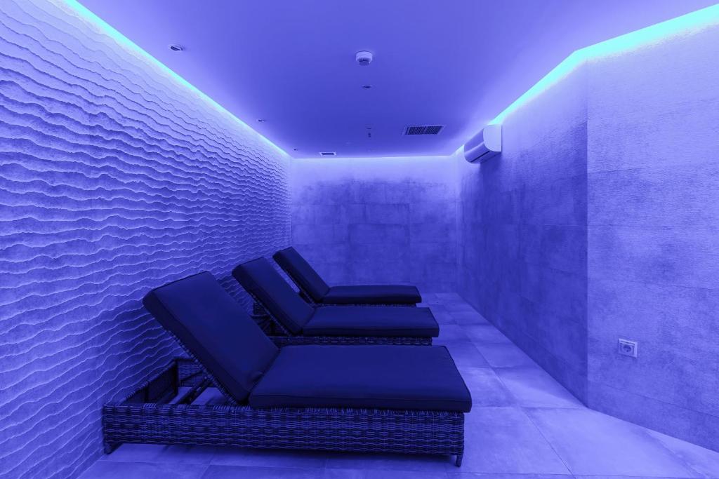 Mūsdienīga relaksācijas telpa ar ērtām sauļošanās gultām un maigu zilganu apgaismojumu, kas rada mierīgu atmosfēru.